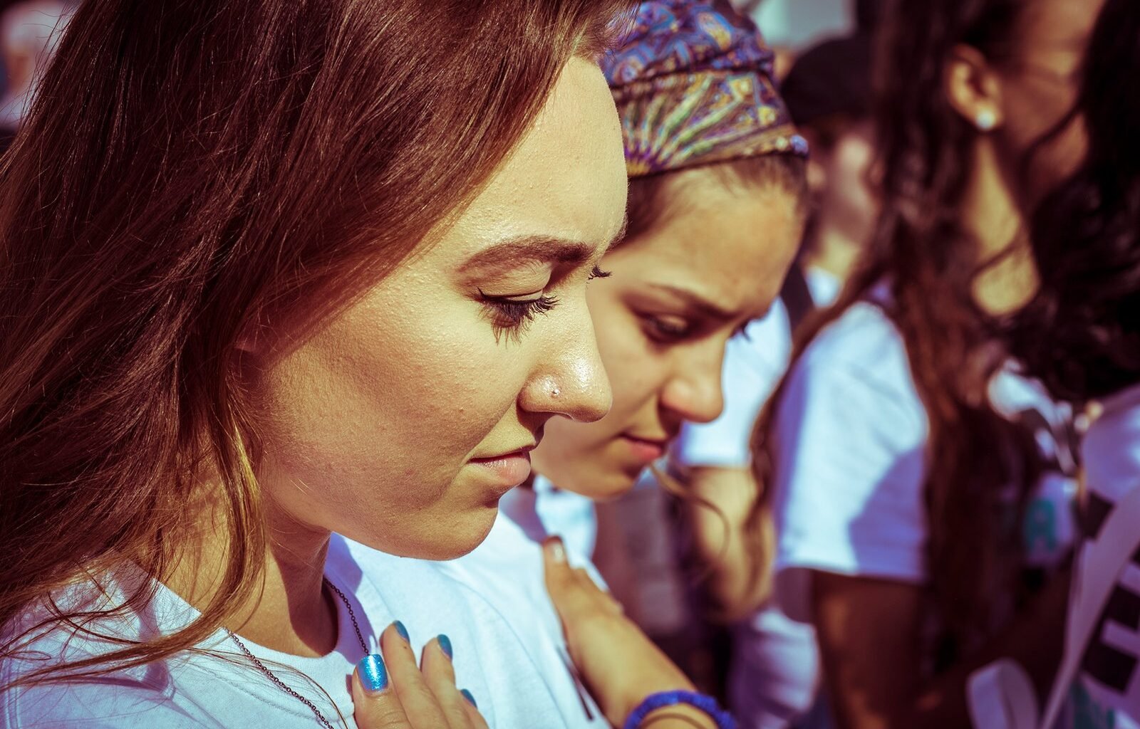 Young girls with their hand on their hearts during the singing of the National Anthem